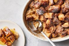 a bowl of bread pudding next to a plate with a spoon