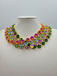 These Anna Wintour style statement necklaces are made with beautiful rivoli crystals in a range of colours, there is 12mm Grass Green, 12mm Hyacinth AB, 12mm Peridot AB and 12mm Topaz AB. The crystals are accentuated beautifully with the gold yellow setting. You can wear them separately or layer them all together for full impact,  sure to get compliments and attention. Their versatility makes them perfect for parties and other celebratory gatherings. Quality of the stones and settings makes them a perfect candidate for becoming heirloom pieces. It is elegant, classy and very "Anna Wintour style". Each necklace is accompanied by a pair of coordinated "FREE GIFT" earrings. Crystals - 12mm Rivoli point back strass. Crystal Colour Grass Green. Necklace setting - Gold plated Brass (nickel, cadm Luxury Multicolor Wedding Necklace, Luxury Multicolor Faceted Beaded Necklaces, Luxury Green Necklaces With Colorful Beads, Luxury Multicolor Faceted Beads Necklaces, Luxury Multicolor Gemstone Bridal Necklace, Elegant Multicolor Rhinestone Necklaces, Green Multi-stone Fine Jewelry Necklaces, Elegant Multicolor Rhinestone Necklace, Luxury Multicolor Beaded Necklace Statement Piece