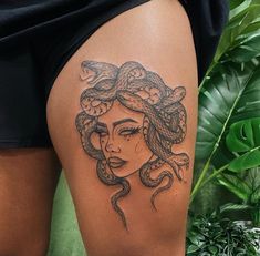 a woman with a snake tattoo on her thigh