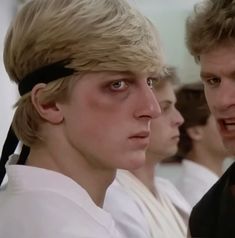 two young men wearing headbands in front of a mirror