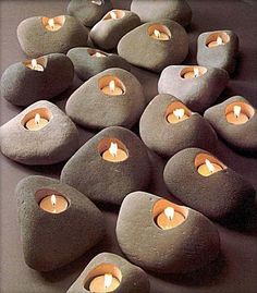 several rocks with lit candles in them