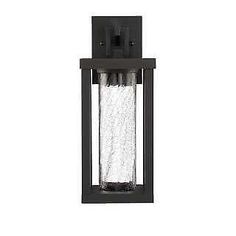 an outdoor wall light with a clear glass cover on the front and side panels, black finish