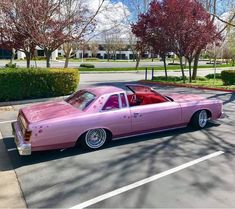 a pink car parked in a parking lot