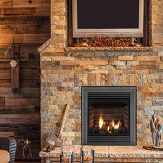 a living room with a stone fireplace and television mounted above the fire place in it