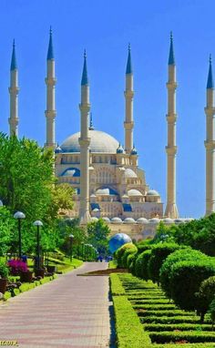 a large building with many spires on top of it's sides and trees in the foreground