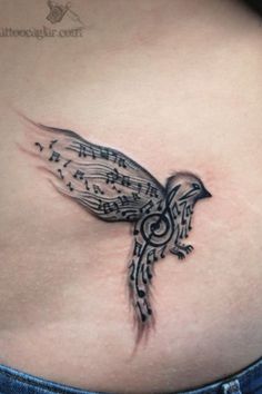 a woman's stomach with music notes on it and a bird tattoo design on the side