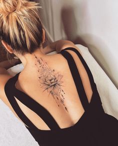 a woman with a flower tattoo on her back