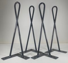 three black metal stands with handles on each side