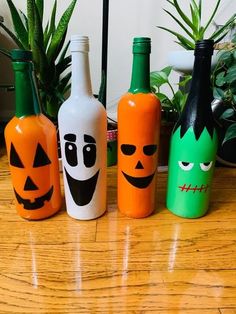 four halloween bottles with faces painted on them