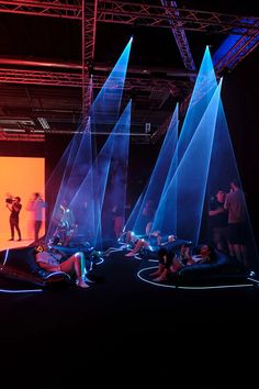 several people on stage with blue lights in the background and one person taking a photo