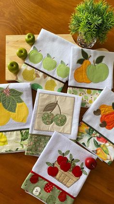 four placemats with apples, oranges and pears on them sitting on a table