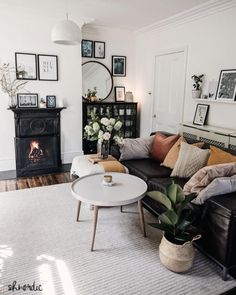 a living room filled with lots of furniture and pictures on the wall above it's fireplace