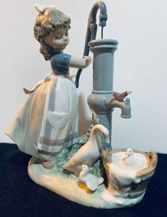 a figurine of a girl drinking water from a faucet