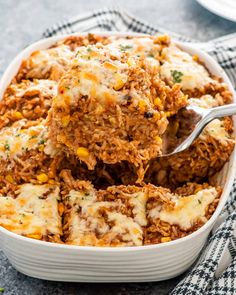 a casserole dish with meat and cheese being lifted from the casserole