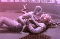 a man laying on the ground next to an alien