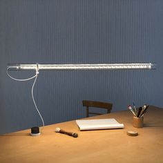 a light that is on top of a table next to a pen and pencils