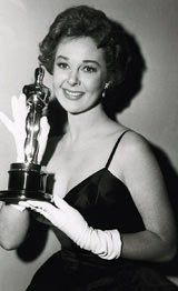 an old black and white photo of a woman holding her oscar award