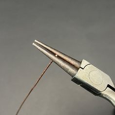 the tip of a pair of pliers is being used to cut wire with scissors