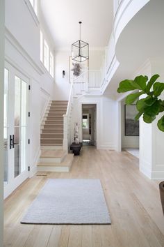 a large white house with stairs leading up to the second floor and an entry way