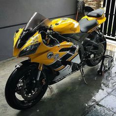 a yellow and black motorcycle parked in front of a building