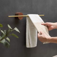 a person is holding a towel on the wall and pulling it up with their hand