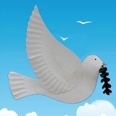 a white dove flying through the sky with a black string in its beak and clouds behind it