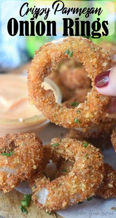 the onion rings are being held up by someone's hand