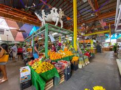 people shopping at an open air market with fresh fruits and vegetables