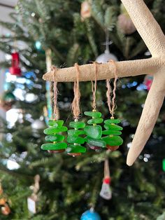 an ornament hanging from a tree with green sea glass beads and twine