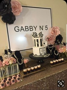 a table topped with cakes and cupcakes next to a sign that says gabby n'5