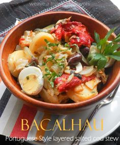 a bowl filled with pasta and vegetables on top of a striped table cloth next to a fork