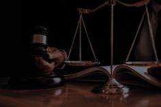 a judge's gavel sitting on top of a wooden table next to an open book