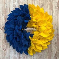 two large yellow and blue flowers on a wooden background with the words plan be crafts