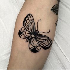 a black and white butterfly tattoo on the arm