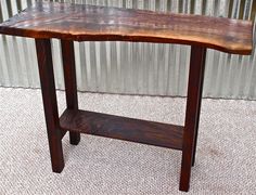 a wooden table sitting on top of a carpeted floor next to a metal wall