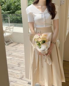 a woman holding a bouquet of flowers in her hands