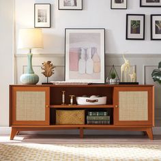 a living room with pictures on the wall and an entertainment center in front of it