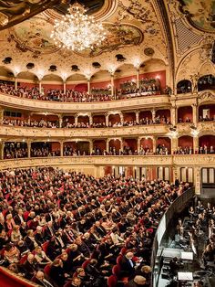 an auditorium full of people sitting and standing