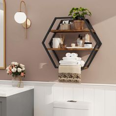 the bathroom is decorated in neutral colors and has shelving shelves with towels, soaps, and flowers