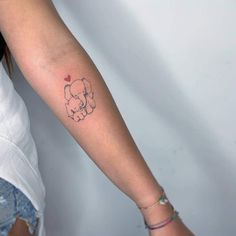 a small elephant tattoo on the left forearm and arm, with a heart in it's trunk