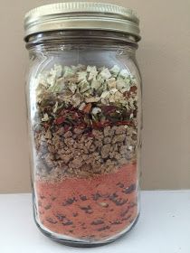 a jar filled with lots of different types of granola on top of a table