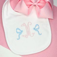 a baby bib with a pink bow on it