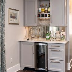 a kitchen with gray cabinets and marble counter tops