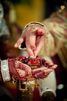 the hands of two people wearing wedding jewelry