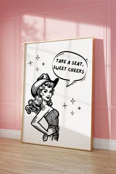 a framed poster with a cartoon girl saying take a seat, sweet cheeks on it