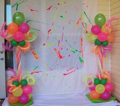 some balloons and streamers are on the ground in front of a white backdrop with a door