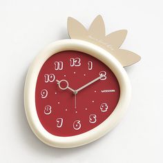 a red clock with white numbers and a pineapple on the face is shown in front of a white background