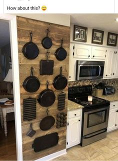 a kitchen with pots and pans mounted to the wall next to stove top oven