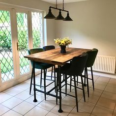 a dining room table with four chairs and a potted plant