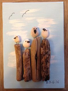 three little birds sitting on top of some wood logs with seagulls flying above them